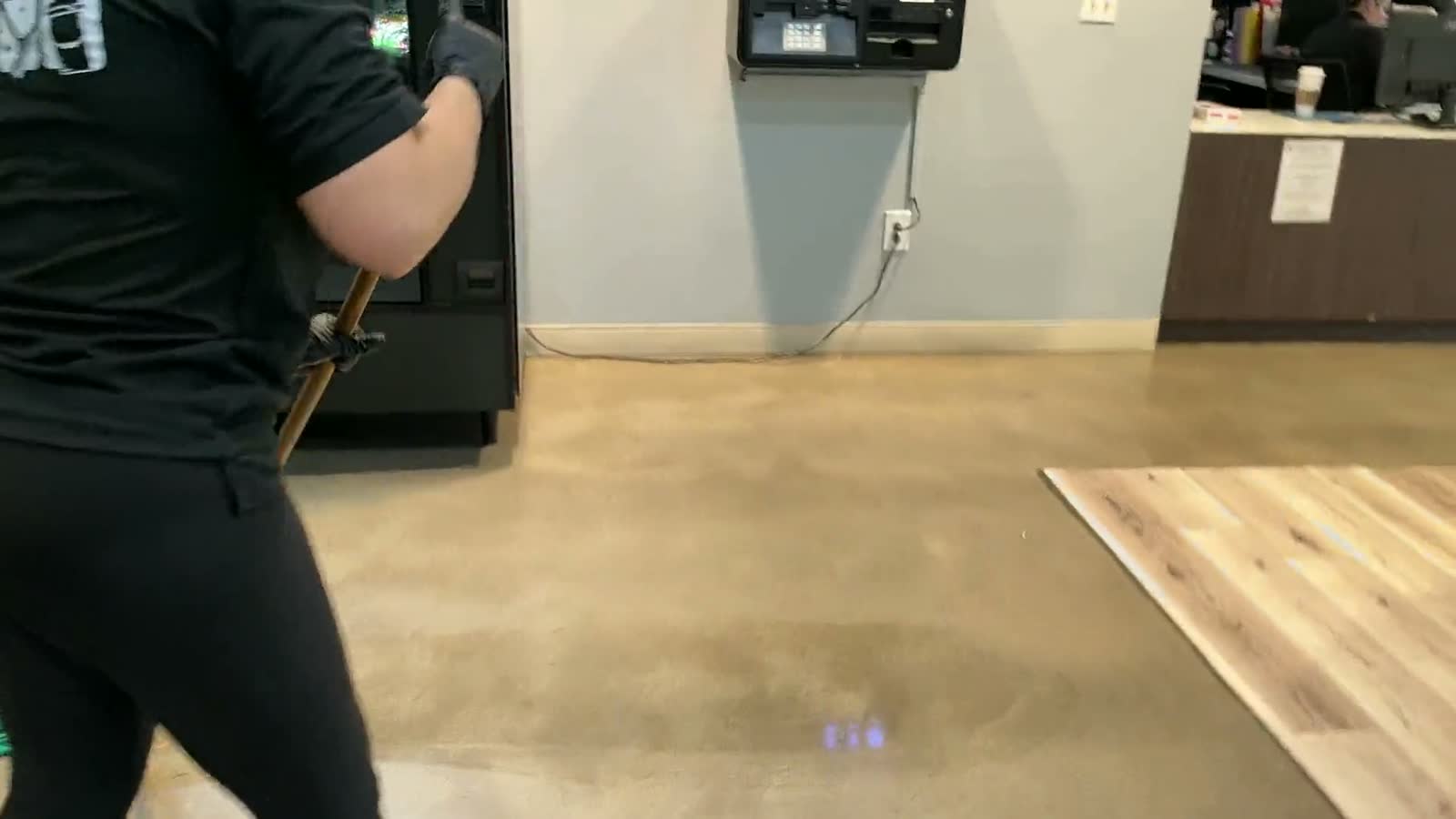 A cleaner polishing a large restroom mirror